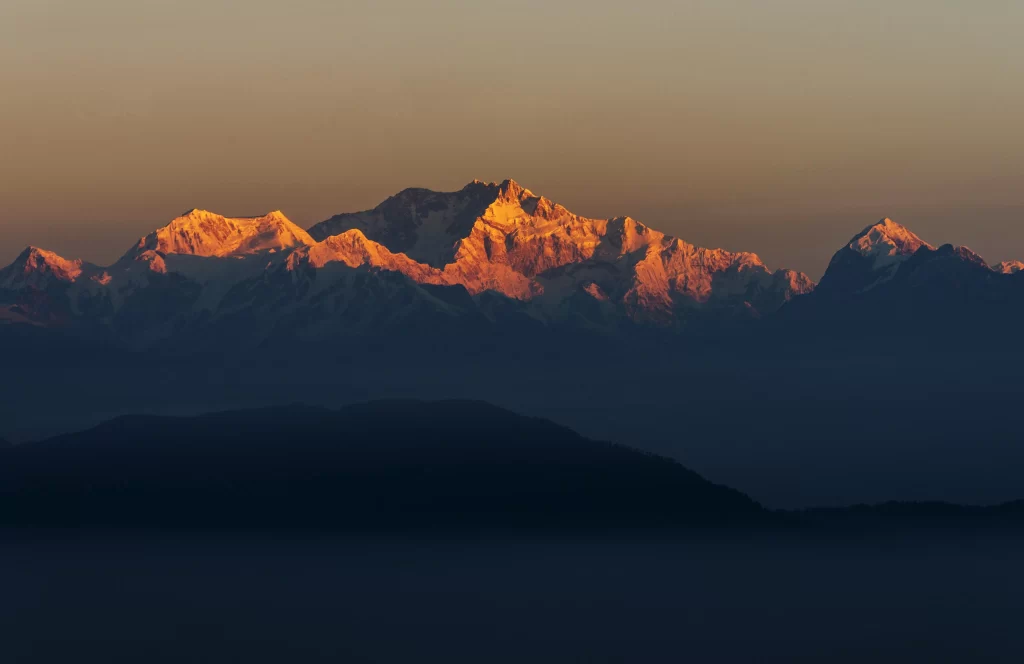 sunset golden snow peak ridge teal blue valley orange