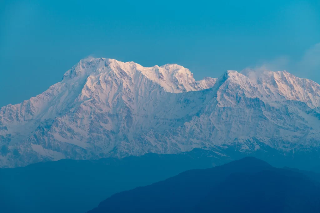 sunset snow-capped peaks golden tranquil blue sky rugged terrain mountain