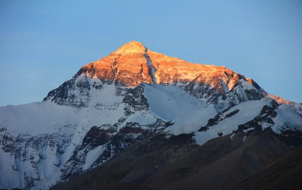sunset snow-capped peaks golden clear sky rugged terrain mountain ridges