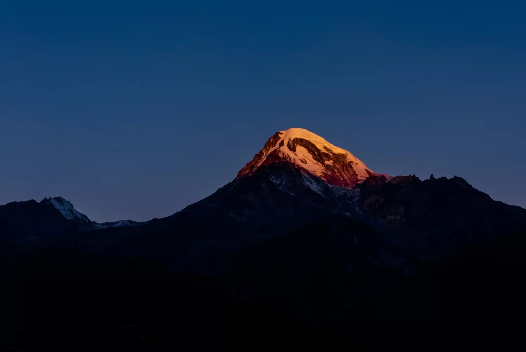 sunset twilight golden deep blue sky snow-capped peak rugged terrain