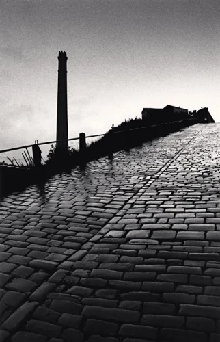 Cobblestone Pathway Industrial Chimney Silhouette High Contrast Dramatic Atmospheric