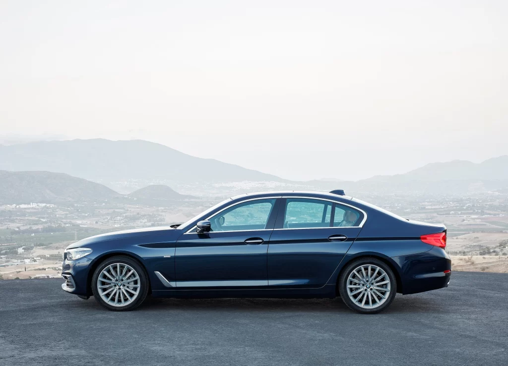 Blue BMW Sedan Scenic Road Side View