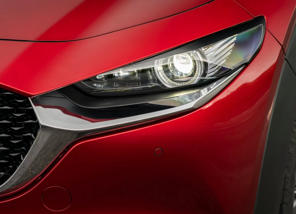 Red Mazda Hatchback Headlight Close Up