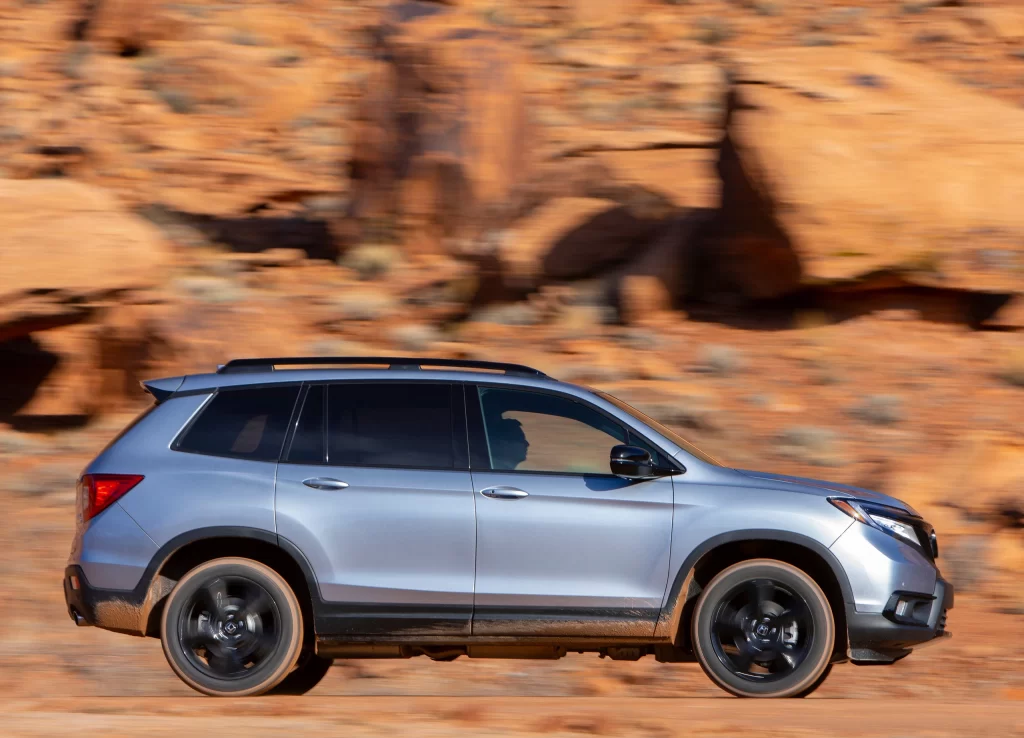 Silver SUV Rocky Road Driving Side View