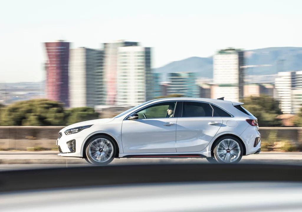 White Kia Hatchback Road Motion Side View